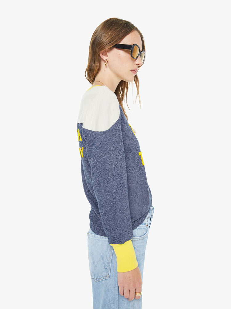 Side view of a woman in a navy  long-sleeve top with a crew neck, boxy fit and extra-long ribbing at the wrists