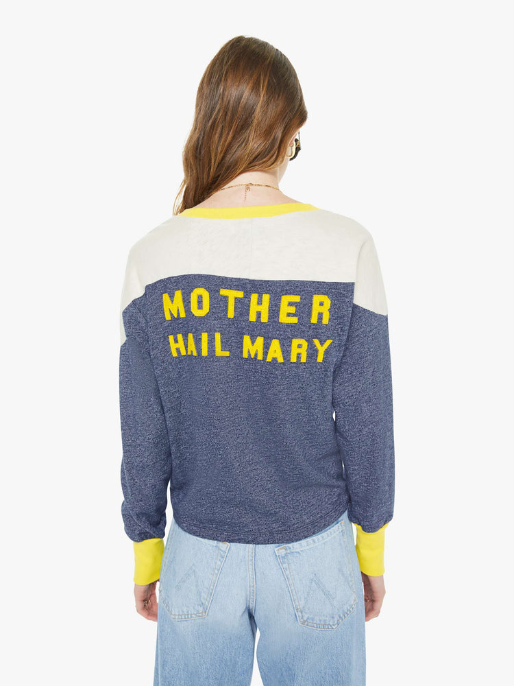 Back view of a woman in a navy  long-sleeve top with a crew neck, boxy fit and extra-long ribbing at the wrists