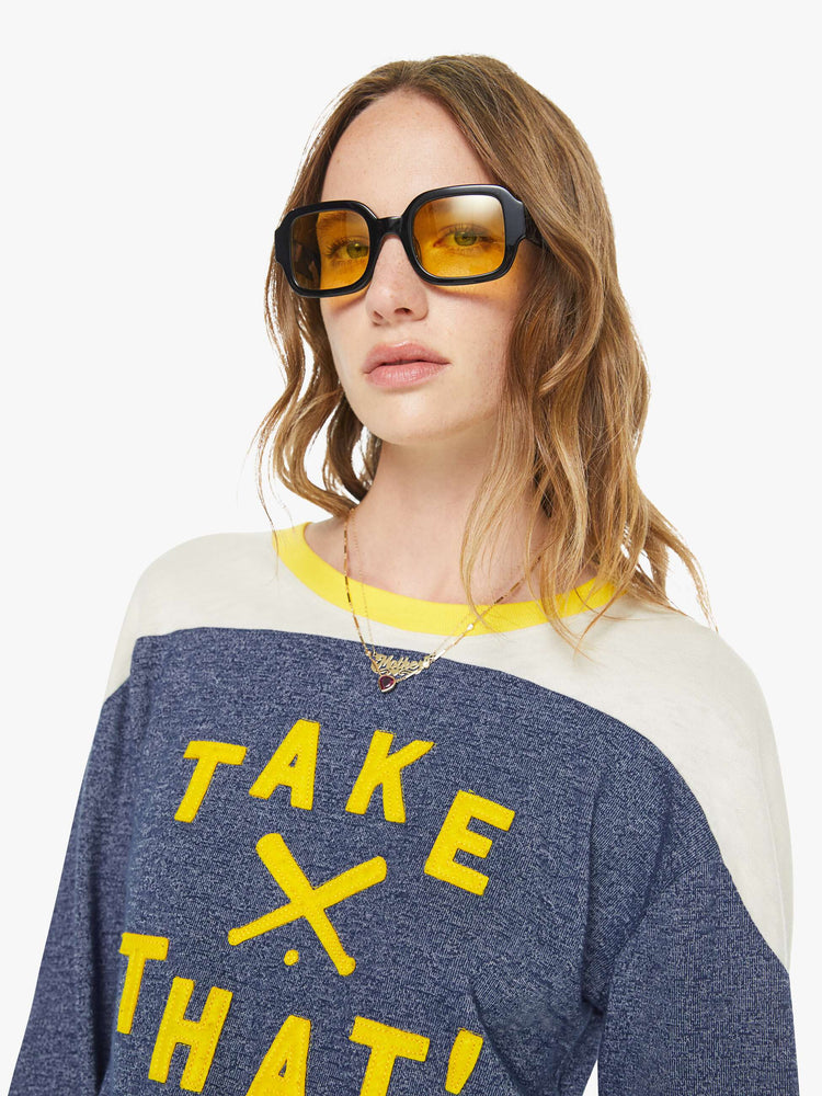 Close up view of a woman in a navy  long-sleeve top with a crew neck, boxy fit and extra-long ribbing at the wrists