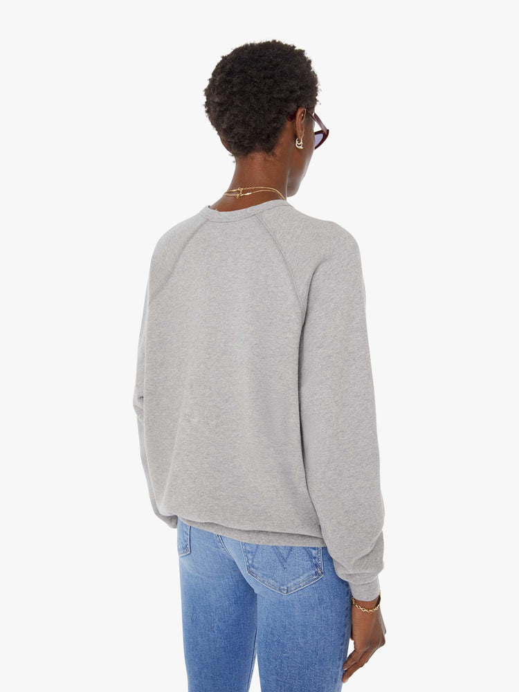 Back view of a woman in a grey oversized raglan sweatshirt with a crewneck, ribbed hems and a slightly cropped fit.