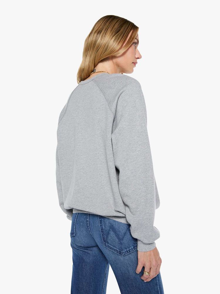 Back view of a woman in a grey oversized raglan sweatshirt with a crewneck, ribbed hems and a slightly cropped fit.