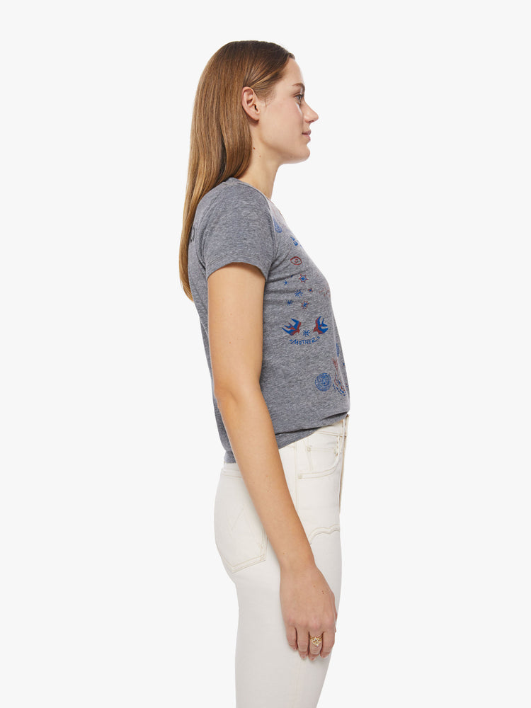 Side view of a woman heathered grey hue sheer crewneck with hand-drawn animal doodles in red and blue on the front and athletic-inspired black text and a number on the back.