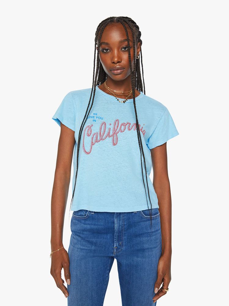 Front view of a woman crewneck with a slim fit in sky blue, the knit tee pays homage to the Golden State with a red and blue text graphic across the chest. 