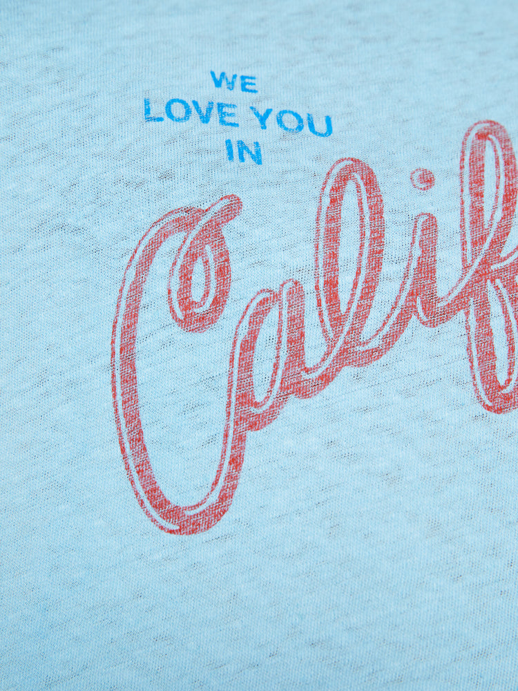 Swatch view of a woman crewneck with a slim fit in sky blue, the knit tee pays homage to the Golden State with a red and blue text graphic across the chest.