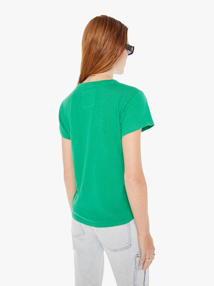 A back view of a woman wearing a green crew neck tee paired with a light blue wash jean.