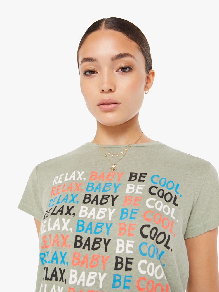 Front close up view of a faded green crew neck tee featuring a colorful graphic reading "RELAX, BABY BE COOL."