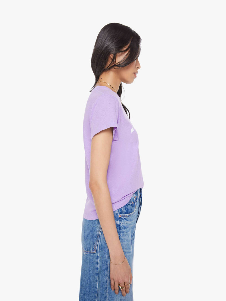 Side view of a woman in a slim fit lavender tee with white faded graphic.