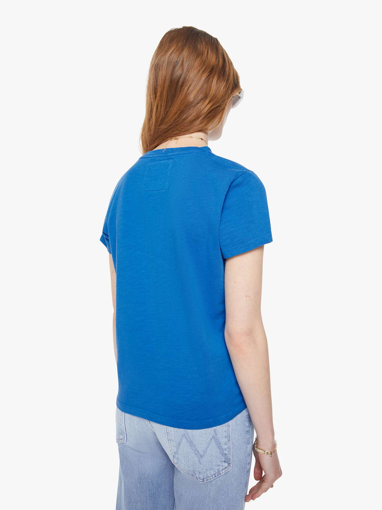 Back view of a woman in a blue tee with a red and white text graphic on the front.