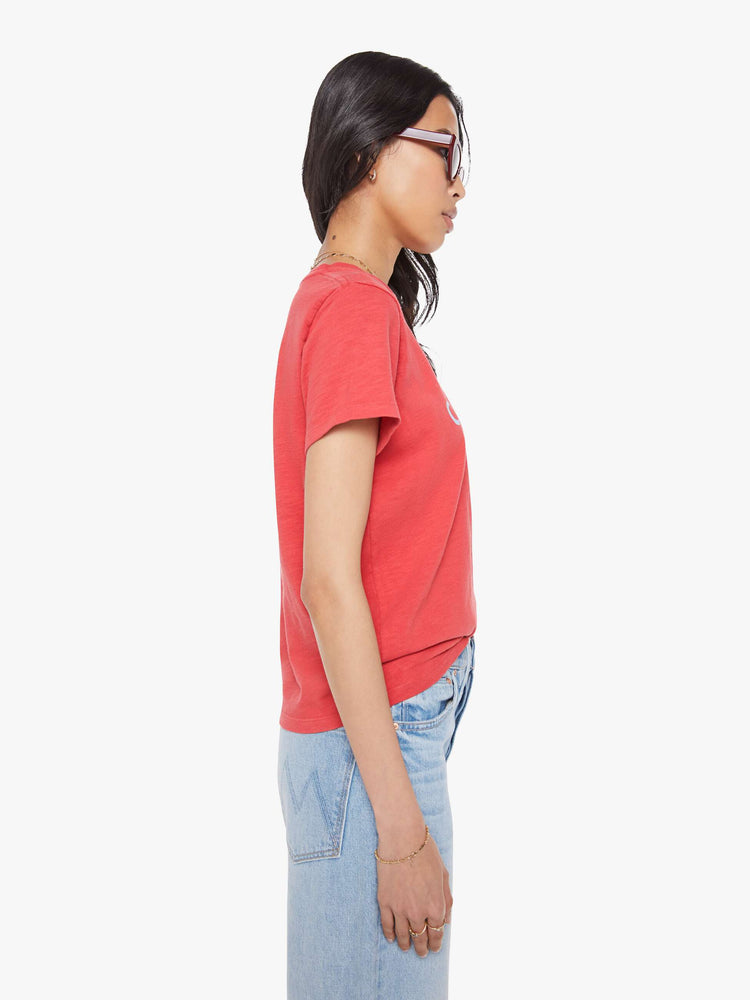 Side view of a woman in a faded red tee with a white text graphic on the front.