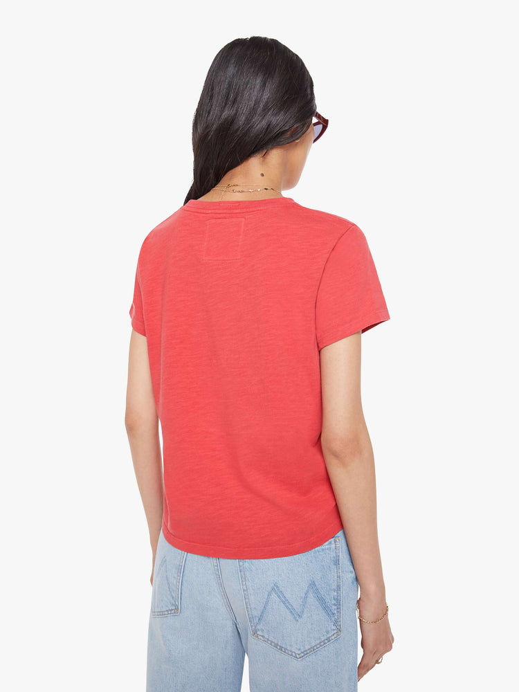 Back view of a woman in a faded red tee with a white text graphic on the front.
