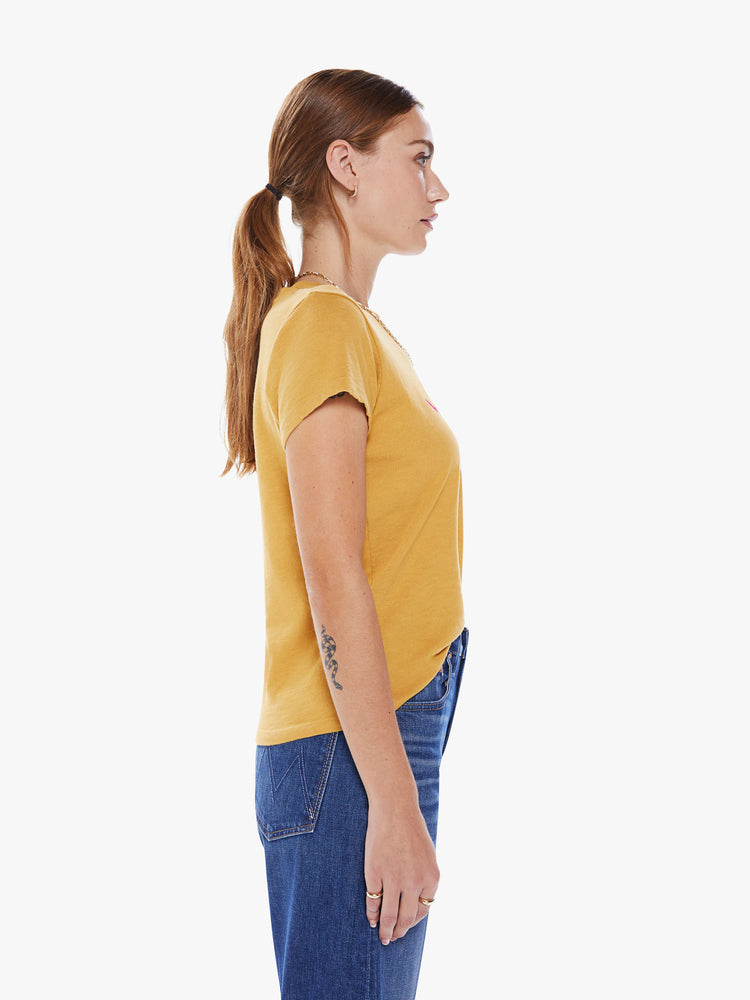 Side view of a woman crewneck with a slim fit in a yellow hue, the tee features a tropical hot pink graphic with text on the front.