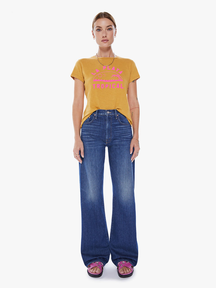 Full body view of a woman crewneck with a slim fit in a yellow hue, the tee features a tropical hot pink graphic with text on the front.