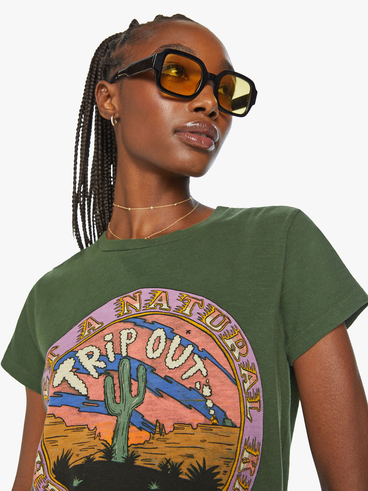 Close up  view of a woman forest green tee features a national park-inspired desert graphic with text on the front.