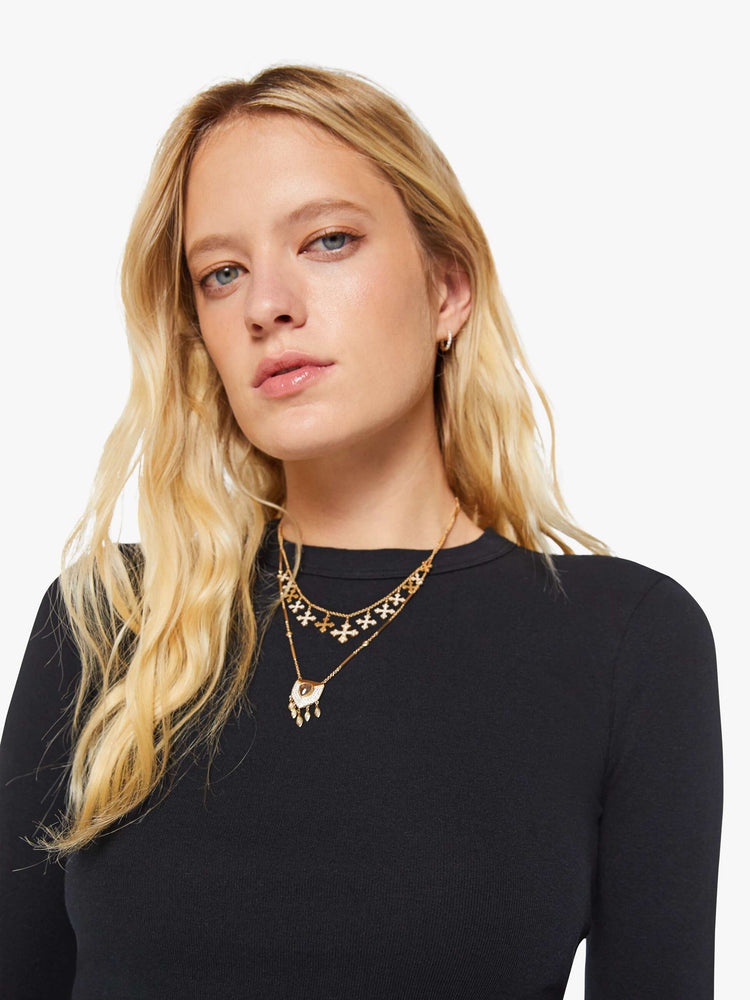 Close up view of a woman in a black shrunken crewneck tee with long sleeves and a cropped length.