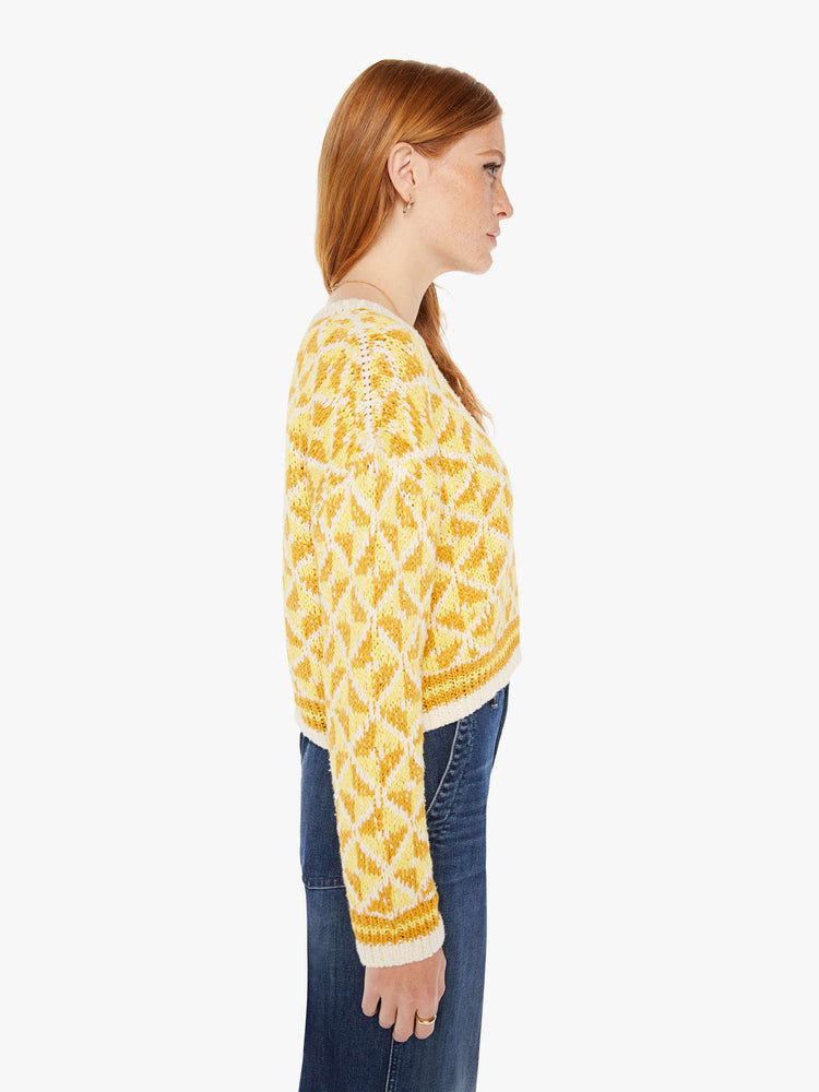 Side view of a womens knit sweater featuring a yellow gemetric pattern.