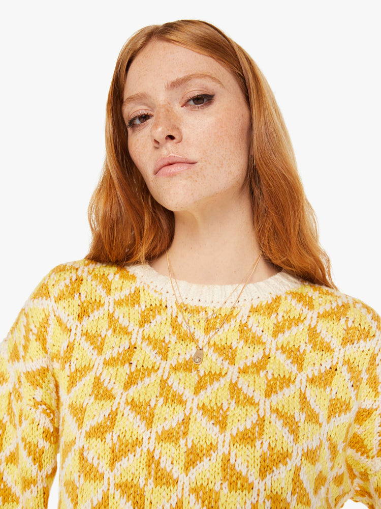 Front close up view of a womens knit sweater featuring a yellow gemetric pattern.