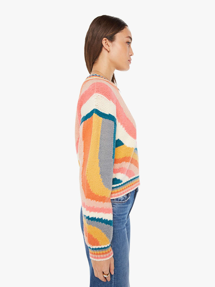 Side view of a womens knit sweater featuring a boxy fit and a wavy multi color pattern.