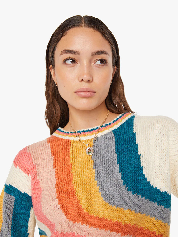 Front close up view of a womens knit sweater featuring a boxy fit and a wavy multi color pattern.