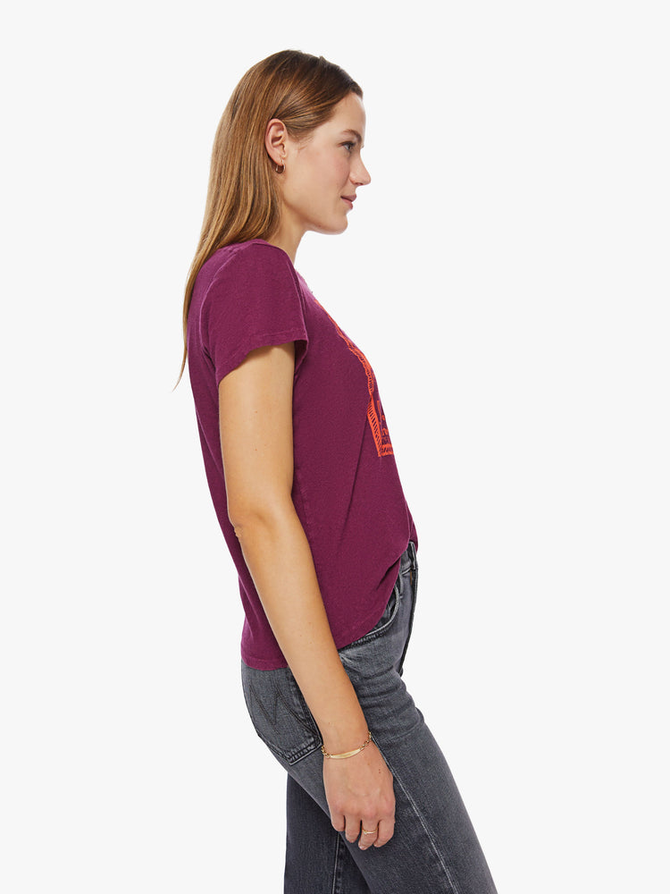 Side view of a woman maroon hue crewneck with a slim fit with an orange graphic inspired by a psychedelic shop from the 60s.