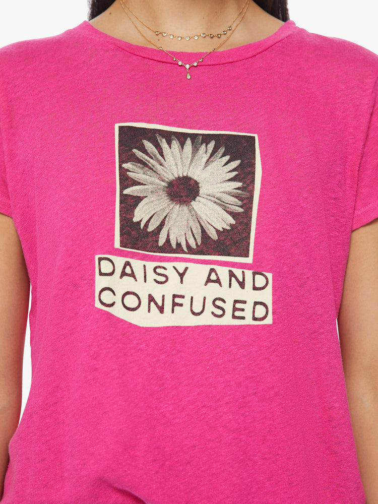 Close up view of a woman crewneck in a hot pink hue, the tee features a high-contrast daisy graphic and text on the front.