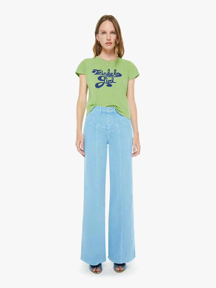 Full body view of a woman in a tee is designed in green with a blue text graphic on the front that reads "Trinket Girl."