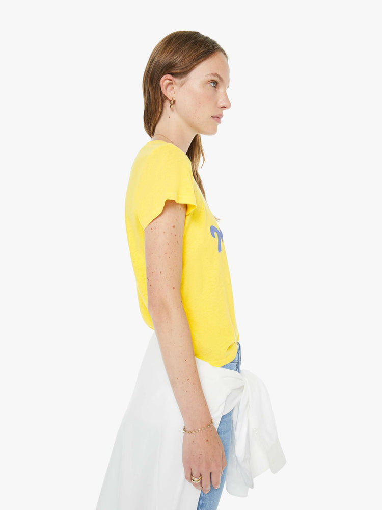 Side view of a woman in a yellow tee with a red apple graphic and MOTHER's name in blue on the front.