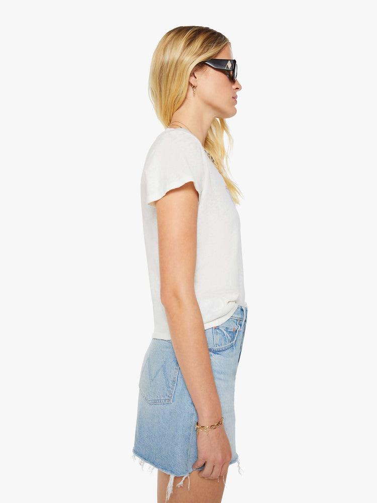Side view of a woman in a white tee with a light blue and red graphic and MOTHER's name on the front.