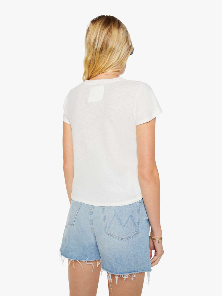 Back view of a woman in a white tee with a light blue and red graphic and MOTHER's name on the front.