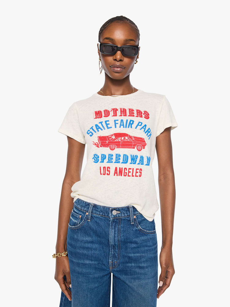 Front view of a woman in an off-white with a vintage-inspired speedway graphic and text in red and blue on the front.