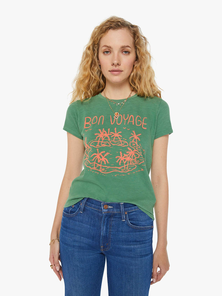 Front view of a woman in a forest green crewneck with a slim fit featuring a hand drawn text graphic "Bon Voyage" in peach styled with blue jeans.
