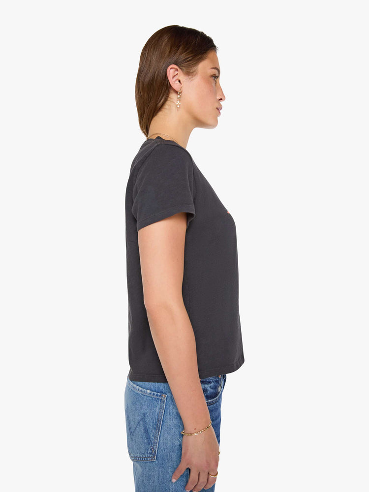 Side view of a woman in a faded black tee with MOTHER's name in a coral crackle-printed starburst graphic on the front.