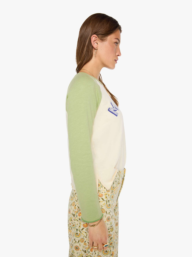 Side view of a woman in a vintage concert tee in off-white with light green sleeves and MOTHER's name in navy block text across the chest.