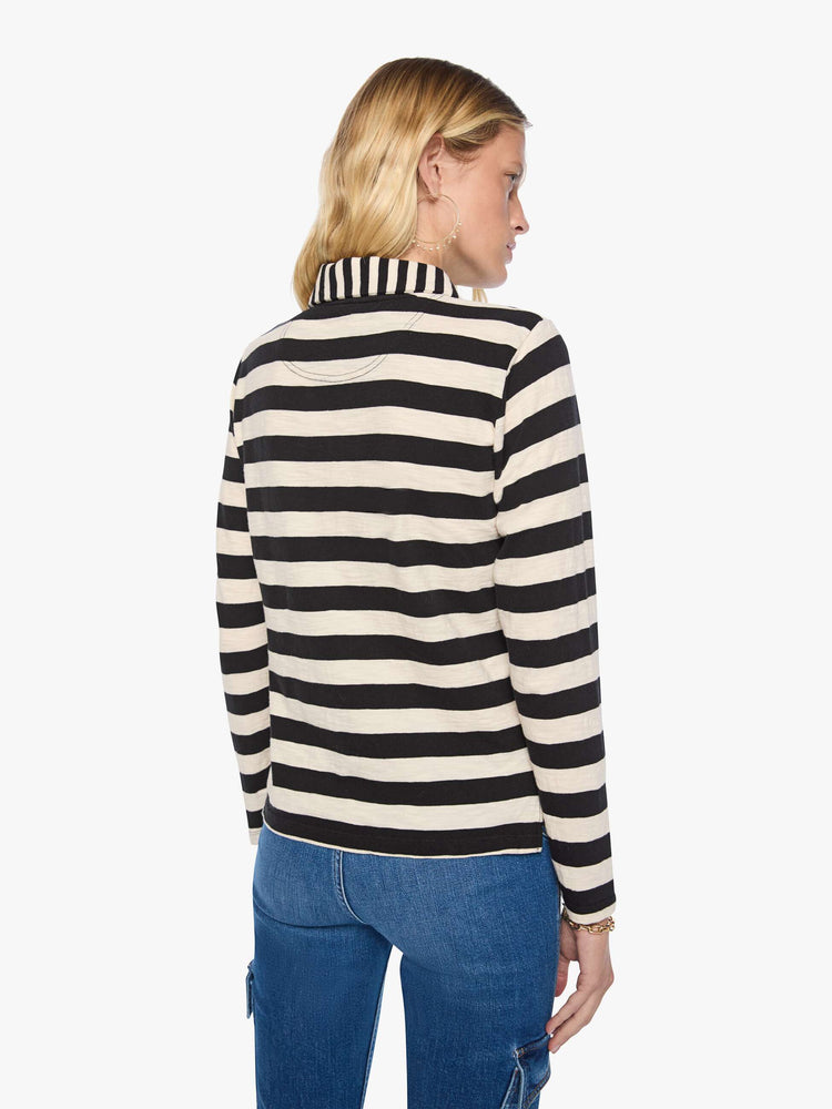 Back view of a woman in black and cream stripes long sleeve top features a fuzzy lamb patch on the chest.