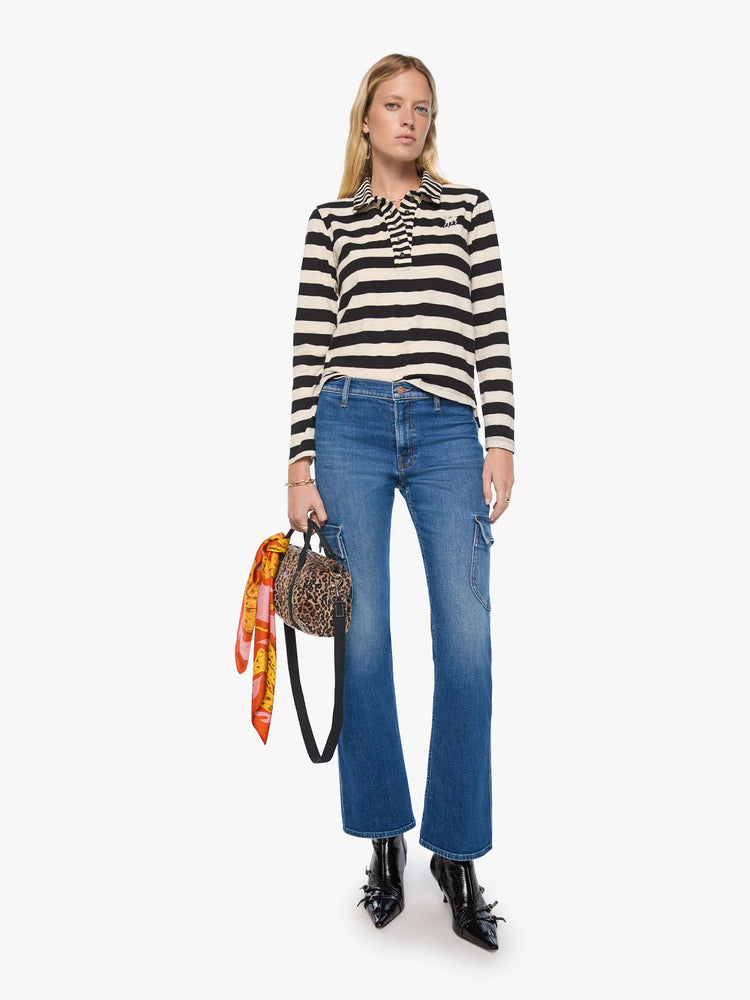 Full body view of a woman in black and cream stripes long sleeve top features a fuzzy lamb patch on the chest.