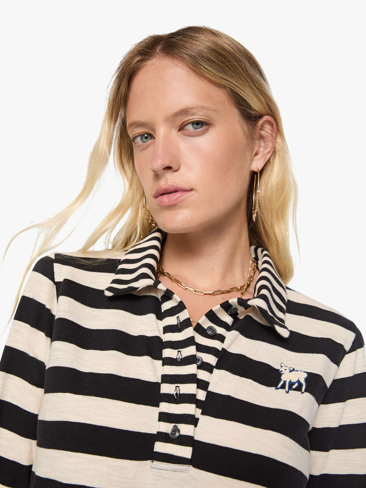 Close up view of a woman in black and cream stripes long sleeve top features a fuzzy lamb patch on the chest.