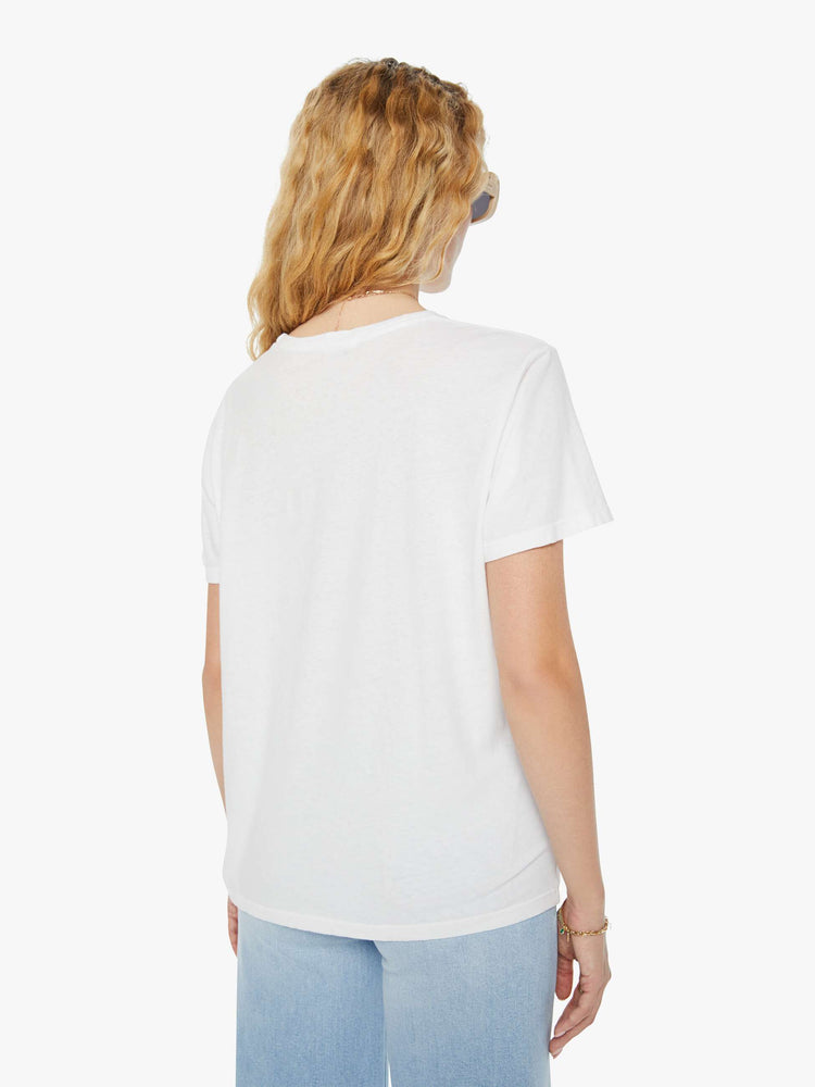 Back view of a woman in a white crewneck tee. Paired with light blue jeans. 