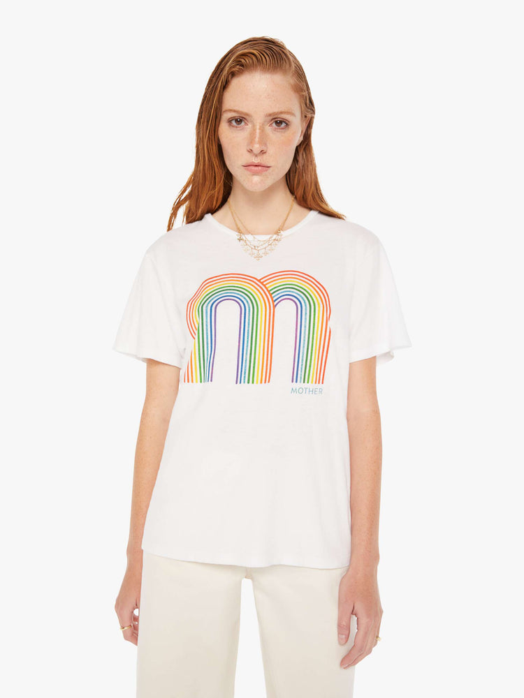 A front view of a woman wearing an oversized white crew neck tee featuring a large double rainbow graphic.