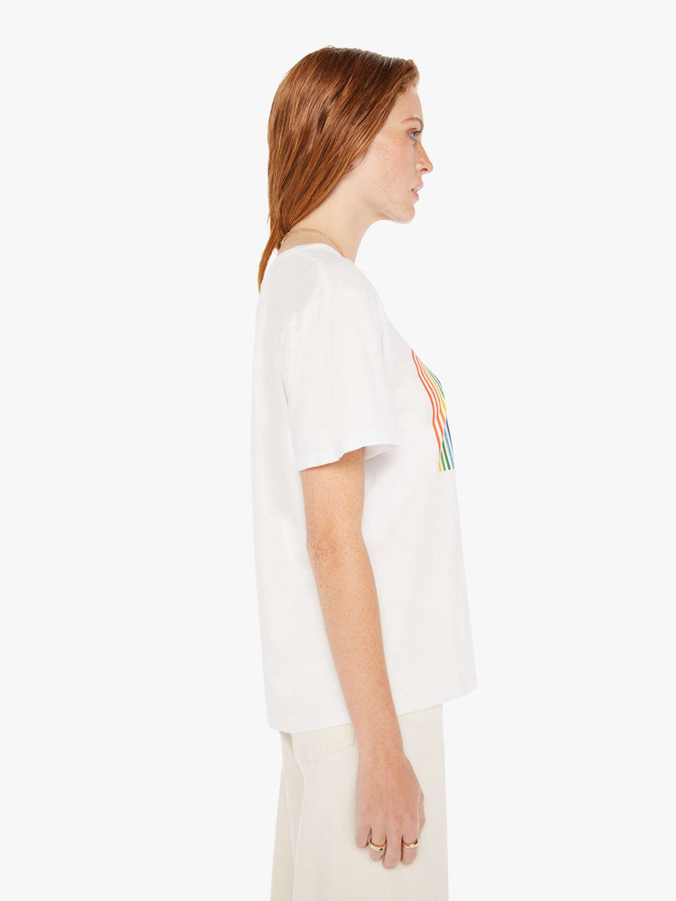 A side view of a woman wearing an oversized white crew neck tee featuring a large front graphic.