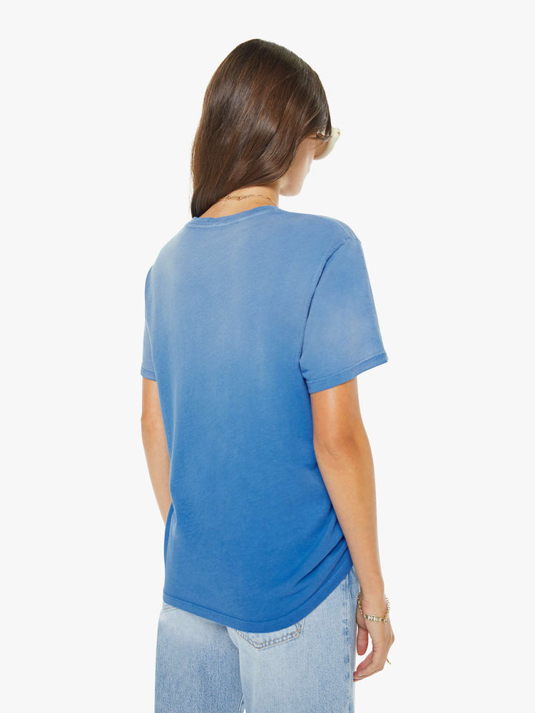 Back view of a woman in faded blue tee with a white fish and lure graphic with text on the front.