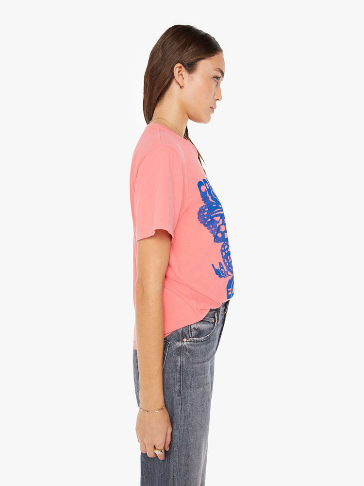 Side view of a womens pink crew neck tee featuring a large blue graphic.
