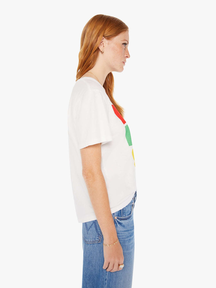 Side view of a woman white oversized crewneck tee with overlapping shades of red, blue, green and yellow on front.