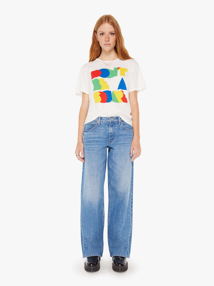 Full body view of a woman white oversized crewneck tee with overlapping shades of red, blue, green and yellow on front.