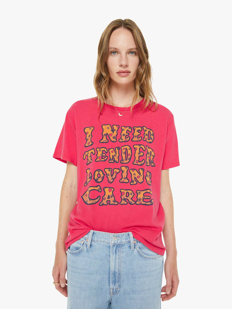 Front view of a woman in a hot pink tee features a subtle message from MOTHER in oversized yellow block text on the front.