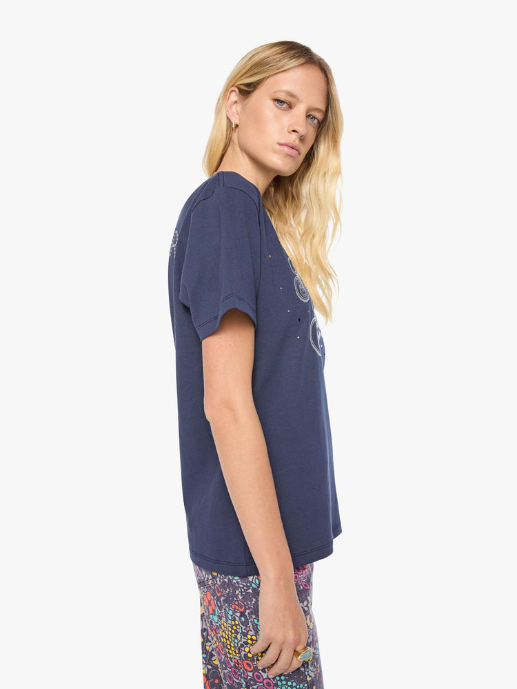 Side view of a woman in dark navy tee with a faded text graphic in white on the front, rhinestone details and MOTHER's name in studs on the back.