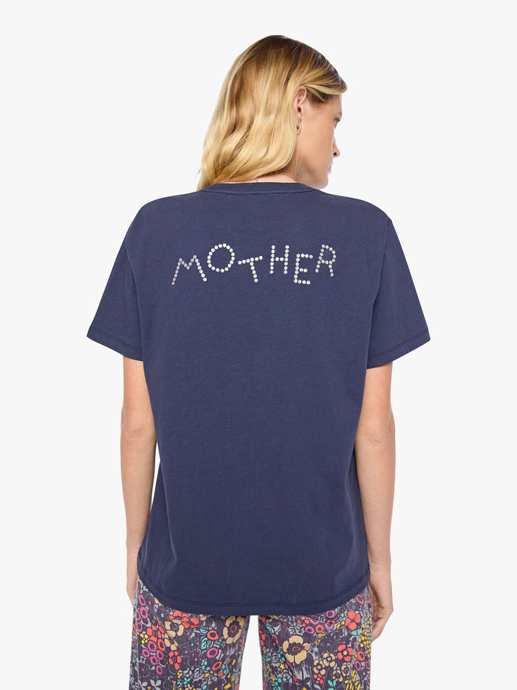 Back view of a woman in dark navy tee with a faded text graphic in white on the front, rhinestone details and MOTHER's name in studs on the back.