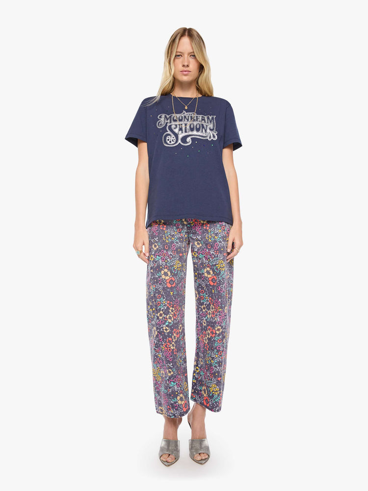 Full body view of a woman in dark navy tee with a faded text graphic in white on the front, rhinestone details and MOTHER's name in studs on the back.