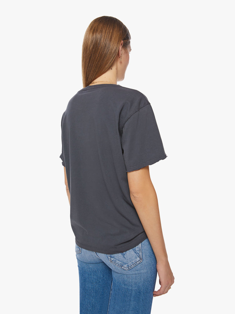 Back view of a woman tee with an oversized fit in a faded black features a torn neckline, distressed details and a white text graphic on the front.