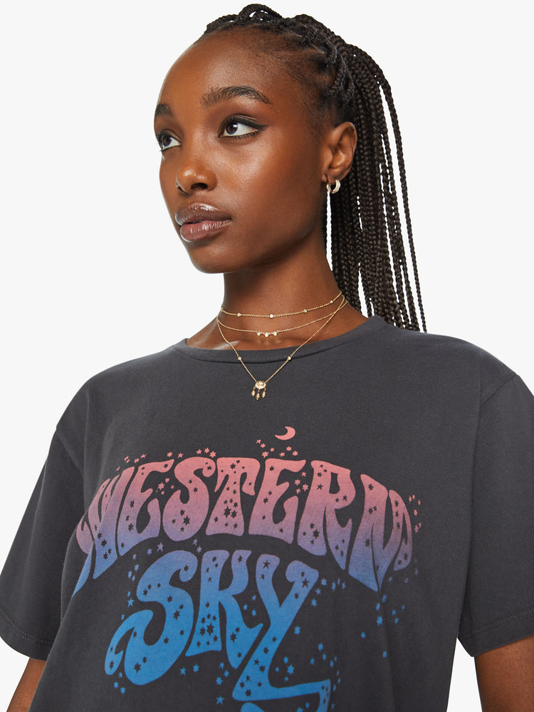 Close up view of a woman crewneck tee with an oversized fit in dark grey tee features a blue and pink text graphic on the front.