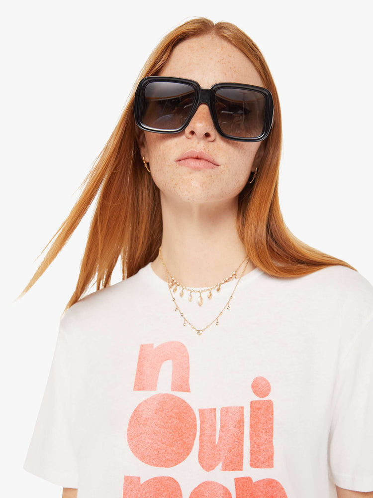 Front close up view of a womens white crew neck tee featuring an oversized fit and a large red graphic.