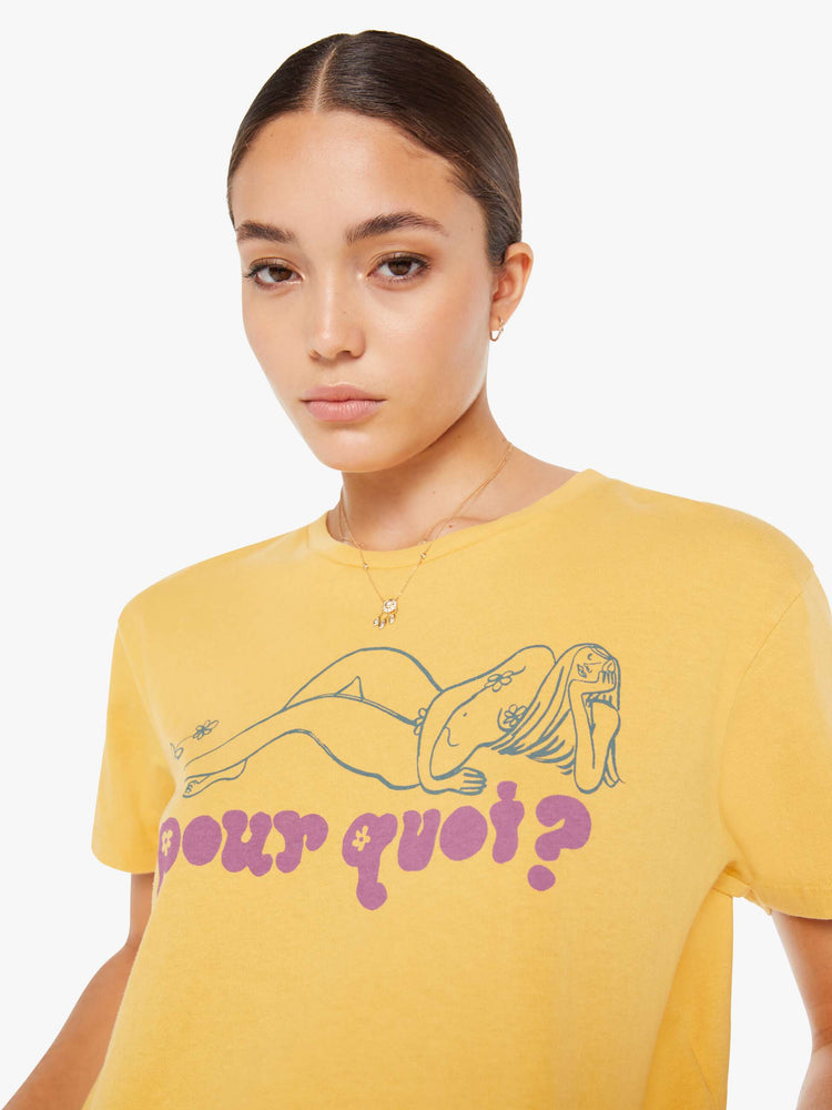 Front close up view of a womens yellow crew neck tee featuring a boxy, cropped fit and a graphic of a woman and "pour quoi?" in purple.
